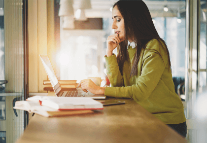 image of a woman sitting at a counter while browsing on a laptop